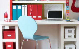 A desk with a laptop and chair in front of it