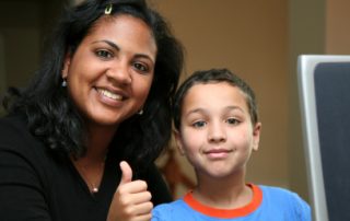 A woman and boy giving thumbs up sign.