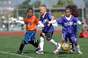 tutor students playing soccer