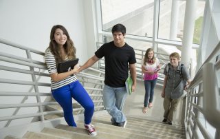 A group of people walking down stairs holding hands.